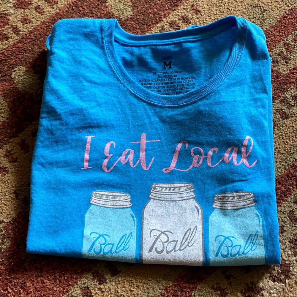 Blue T-shirt. “I eat local because I can”